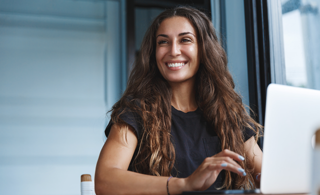 Happy female professional on laptop Happy female professional on laptop